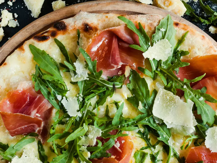 Pizza with procuito, arugula and parmesan