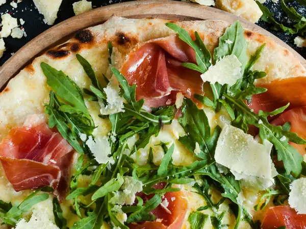 Pizza with procuito, arugula and parmesan